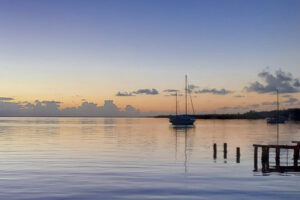 Sunsets in Saigon Bay, Isla Colon, capture sailboats, and orange rim and blue sky.